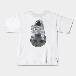 astronaut is thinking something while sitting on the moon Kids T-Shirt